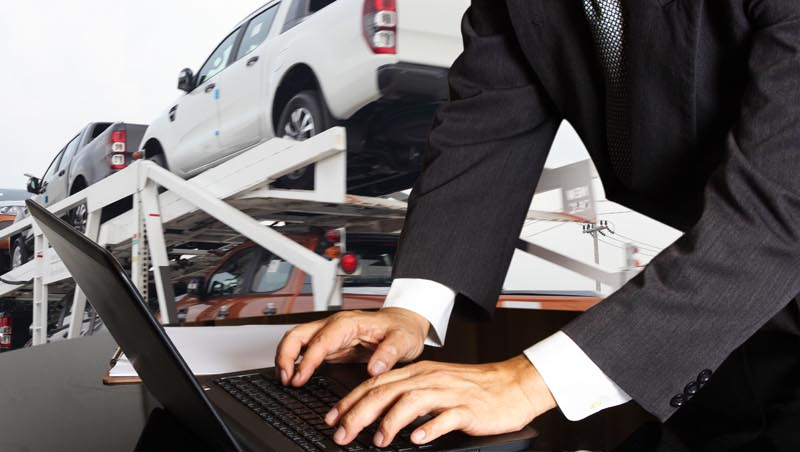 auto shop manager reviewing service appointments on a laptop