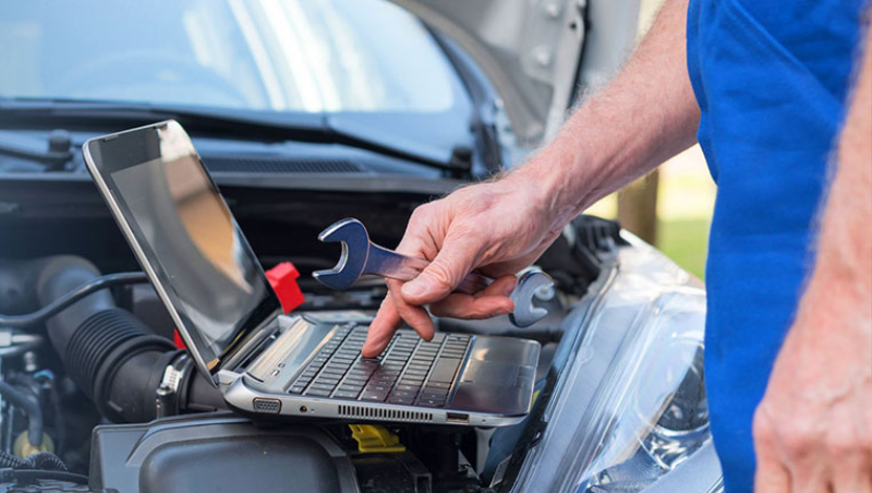 technician reviewing automotive service schedule on a laptop